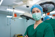 Portrait of Asian surgeon and nurse with medical mask standing with arms crossed in operation theater at a hospital. Team of Professional surgeons. Healthcare, emergency medical service concept
