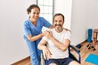 © Krakenimages.com - Middle age man and woman smiling confident having physiotherapy session at physiotherapy clinic