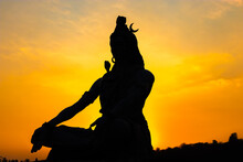 Back Lit Statue Of Hindu God Lord Shiva In Meditation Posture With Dramatic Sky From Unique Angle