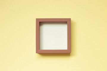 Wall Mural - Pink picture frame on yellow background. top view, copy space