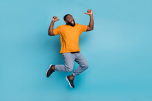 Photo Of Sweet Excited Guy Wear Orange T-shirt Jumping High Pointing Thumbs Himself Isolated Blue Color Background
