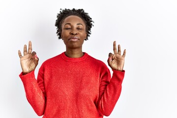 Wall Mural - Young african american woman wearing casual clothes over isolated background relax and smiling with eyes closed doing meditation gesture with fingers. yoga concept.