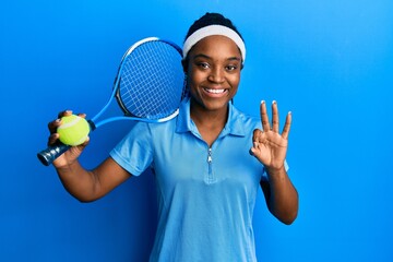 Sticker - African american woman with braided hair playing tennis holding racket and ball doing ok sign with fingers, smiling friendly gesturing excellent symbol