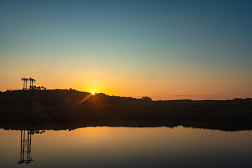 sunrise over mountain shadow and calm lake with reflection at morning from flat angle