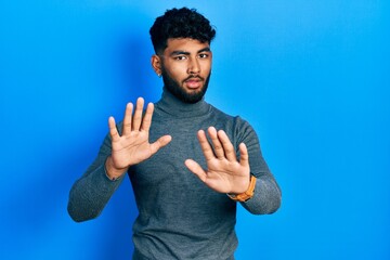 Sticker - Arab man with beard wearing turtleneck sweater moving away hands palms showing refusal and denial with afraid and disgusting expression. stop and forbidden.