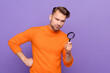 © deagreez - Photo of ponder unsure guy dressed orange pullover looking magnifier empty space isolated purple color background