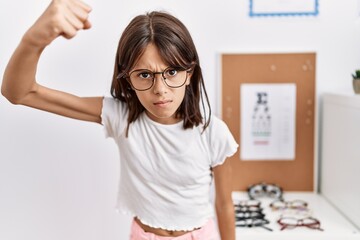 Sticker - Young hispanic girl wearing glasses angry and mad raising fist frustrated and furious while shouting with anger. rage and aggressive concept.