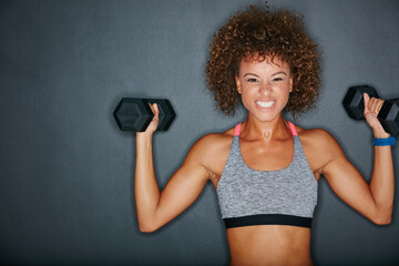 Wall Mural - Theres no room for the weak. Studio shot of a fit young woman lifting weights against a grey background.