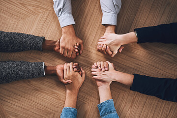 Poster - Teamwork means providing constant support to each other. High angle shot of a group of unidentifiable businesspeople holding hands together in unity.