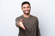 © luismolinero - Young Brazilian man isolated on white background shaking hands for closing a good deal