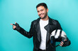 © luismolinero - Young Brazilian woman with a motorcycle helmet isolated on blue background pointing finger to the side