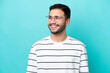 © luismolinero - Young Brazilian man isolated on blue background With glasses with happy expression