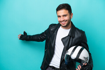 Wall Mural - Young Brazilian woman with a motorcycle helmet isolated on blue background extending hands to the side for inviting to come