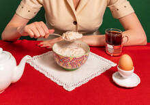 Food Pop Art Photography. Cropped Portrait Of Woman Tasting Porridge On Red Tablecloth Over Green Background. Vintage, Retro Style Interior