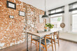 © ADDICTIVE STOCK - Bright dining room with a table and brick wall