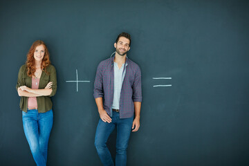 Wall Mural - It can only go one of two ways. Shot of a young couple standing in front of a blackboard with symbols written on it.