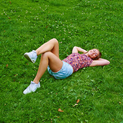 Sticker - Frolicking in nature. Shot of a young woman relaxing on the grass in a park.