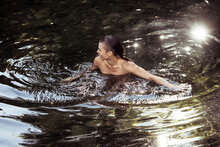 Androgynous Young Person Wading In Luscious Water