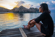 Woman Enjoying The Sunset On A Sailboat In Komodo