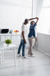 © LIGHTFIELD STUDIOS - full length of happy senior african american couple dancing in kitchen.