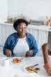 © LIGHTFIELD STUDIOS - senior african american woman talking with husband during breakfast.