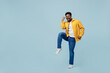 © ViDi Studio - Full body excited young man of African American ethnicity 20s wear yellow shirt doing winner gesture celebrate clenching fists say yes isolated on plain pastel light blue background studio portrait
