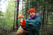 © alexkich - The forester collects mushrooms in the forest. Harvesting wild mushrooms. Hike to the forest park with fly agarics.