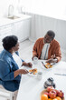 © LIGHTFIELD STUDIOS - high angle view of senior african american man talking with wife during breakfast.