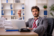 © Elnur - Young male employee unhappy with excessive work in the office