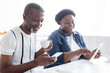 © LIGHTFIELD STUDIOS - senior african american man with cup of coffee using smartphone near blurred wife with digital tablet.