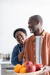 © LIGHTFIELD STUDIOS - senior african american man holding bowl with blurred fruits near smiling wife.