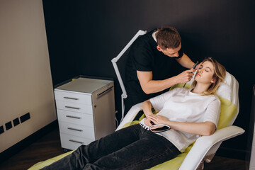 Wall Mural - Plastic surgeon drawing marks on female face in clinic