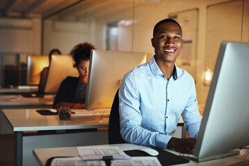 Wall Mural - Here to get ahead of my deadlines. Portrait of a young businessman working late on a computer in an office.