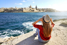 Young Traveler Woman Holds Hat Looking At Valletta Old Town Travel Destination In Malta