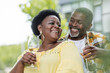 © LIGHTFIELD STUDIOS - positive and senior african american couple holding glasses of wine.