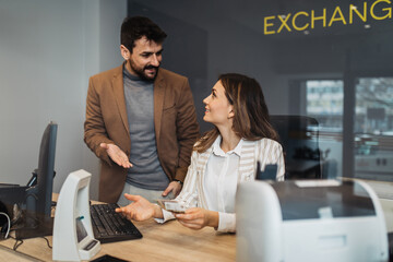 Wall Mural - A man and a woman work together in an exchange office.