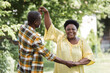 © LIGHTFIELD STUDIOS - senior african american couple dancing and smiling in park.
