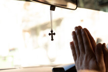 A  cross hanging from the windshield mirror in the car