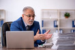 © Elnur - Old male employee and too much work in the office