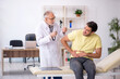 © Elnur - Young male patient visiting old male doctor