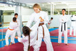 © JackF - Focused school girls wearing white sports uniform practicing karate sparring in pair in gym