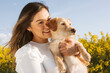 © Eva Corbella - portrait of Young girl hugging her dog with the background of a field of flowers.