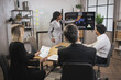© sofiko14 - Beautiful motivated smart african american businesswoman demonstrating infographics on digital board in front of her concentrated multiethnic business team, listening to her nd making notes.