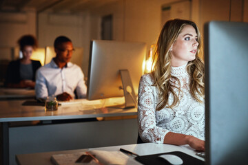 Aufkleber - Theres no questioning her dedication. Shot of a young businesswoman working late on a computer in an office.