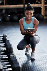 Another day at the gym. Shot of a fit young woman using a digital tablet in a gym.