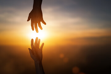 Silhouette of reaching, giving a helping hand, hope and support each other over blur sunset sky background. concept of international day of peace and develop a friendship.