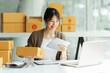 © PaeGAG - Successful Asian women entrepreneur with parcel boxes in her own job shopping online business at home office. start up small business, sme concept.