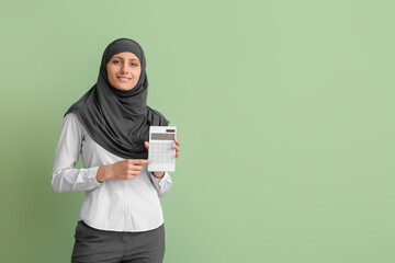 Wall Mural - Muslim secretary with calculator on color background