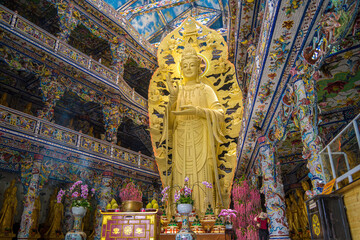 Linh Phuoc Pagoda in Da Lat, Vietnam. Dalat's famous landmark, buddhist porcelain glass temple. Golden Guanyin statue at Linh Phuoc Pagoda is also known as Ve Chai Pagoda