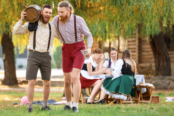 Poster - Drunk men with beer celebrating Octoberfest outdoors